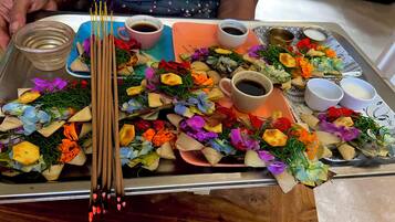 A tray with food items, including a cup of tea, a bowl of soup, and various snacks.