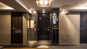A hotel lobby with a reception desk, a digital directory, and a fire alarm. - APA Hotel Higashi Shinjuku Kabukicho Higashi (Tokyo)