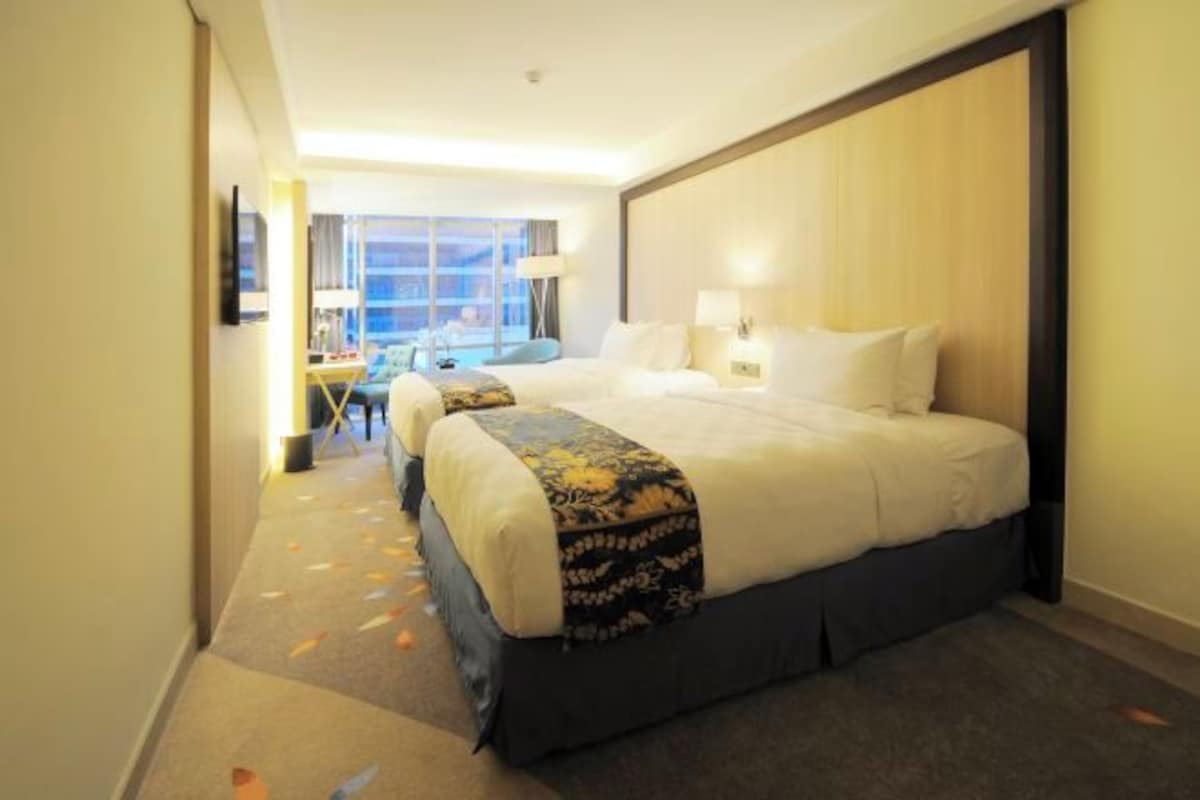 Una habitación de hotel con una cama grande, un escritorio y una silla.