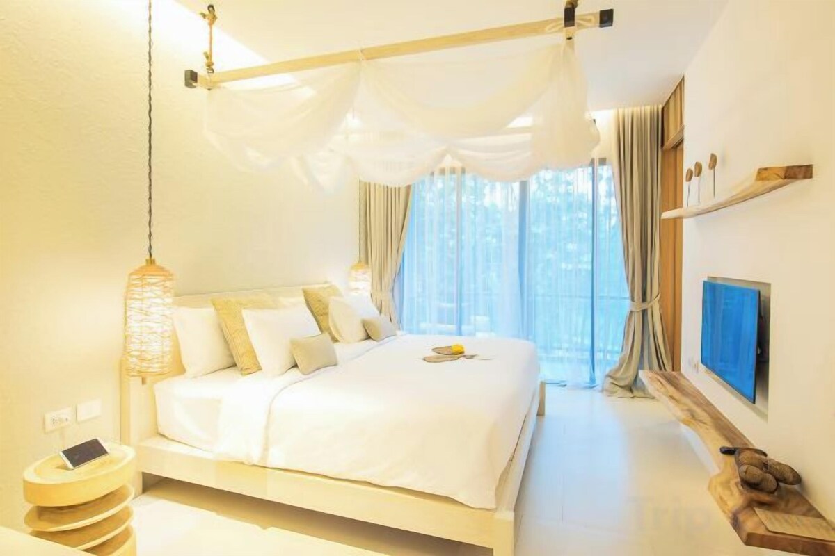 Un dormitorio con cama, mesita de noche y televisor.