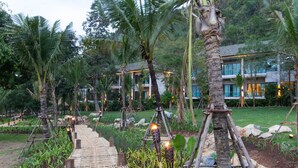 A pathway leading to a building surrounded by palm trees and greenery. - The Series Resort Khaoyai (Pak Chong)