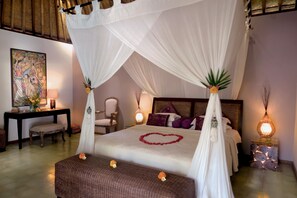 Un dormitorio con cama con dosel, una mesita de noche, una silla y una lámpara de pared.