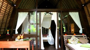 Una habitación con una cama, una mesa con bebidas y vistas por la ventana.