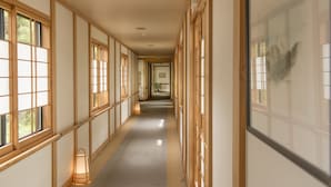 A long corridor with traditional wooden sliding doors and windows, a polished floor, and a lantern on the left. - Nakamurakan (Takayama)