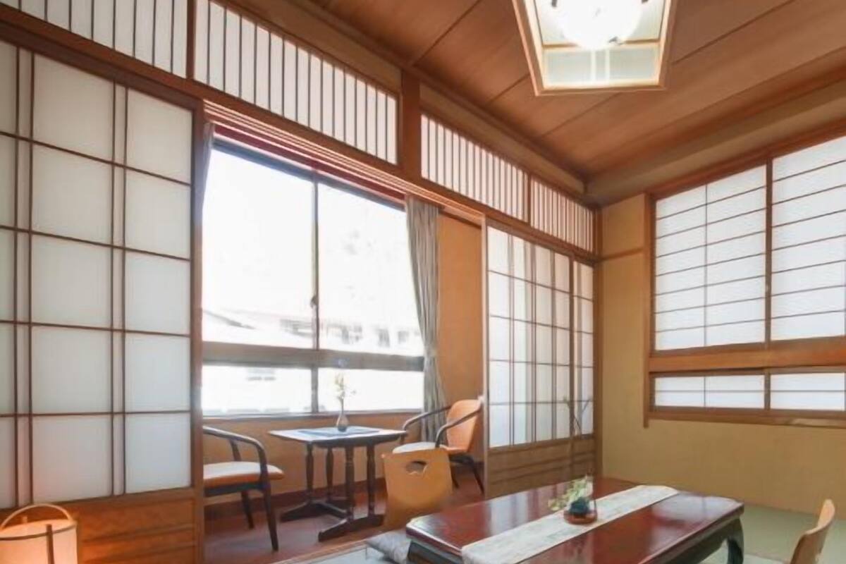 A traditional Japanese room with tatami flooring, a low table, and sliding doors.