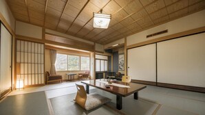 A traditional Japanese room with tatami flooring, a low table, and sliding doors. - Nakamurakan (Takayama)