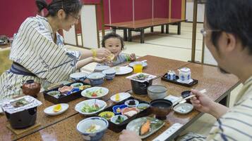 A traditional Japanese meal setting with various dishes and utensils on a table.