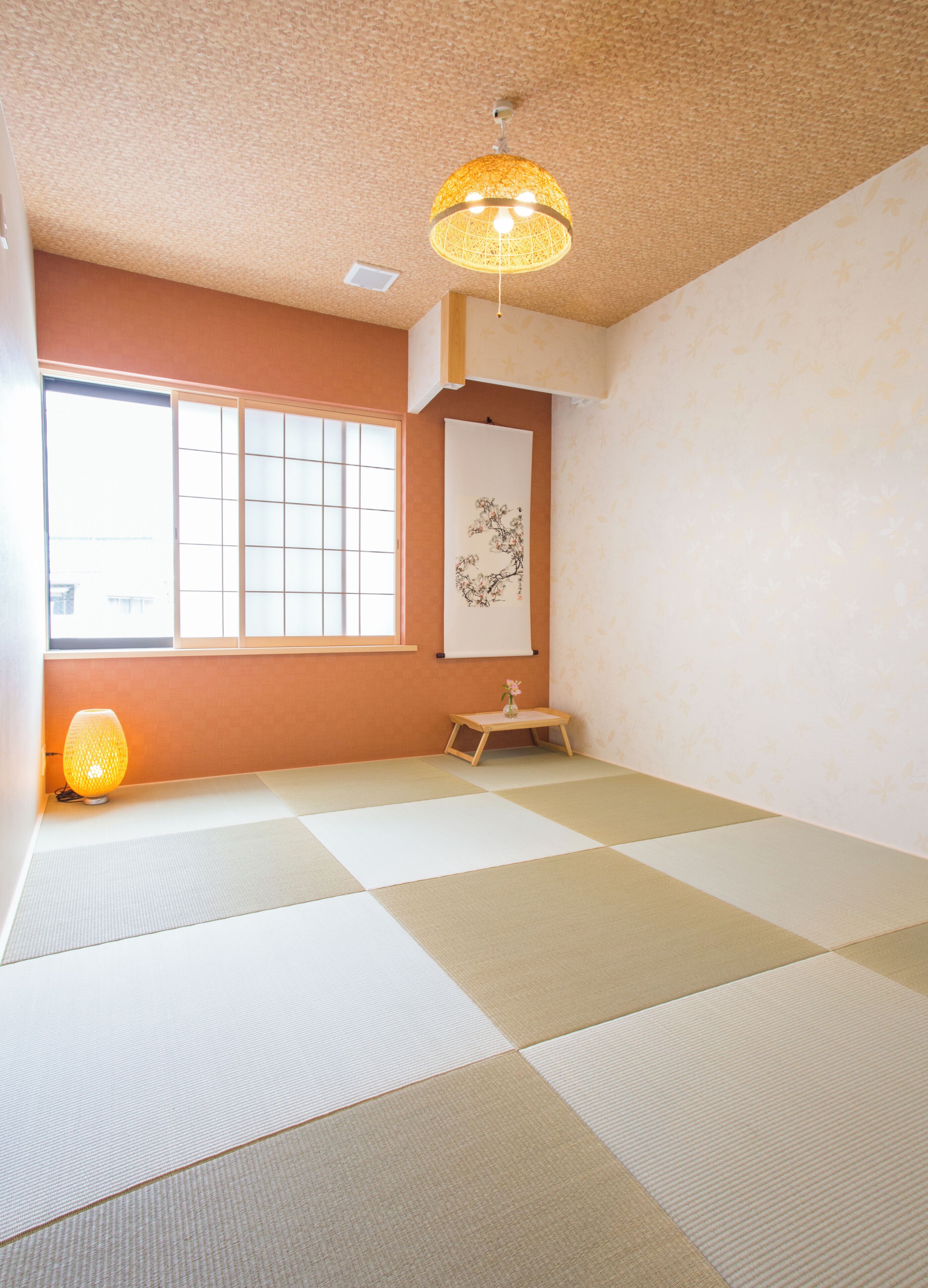 A tatami mat room with a shoji screen, a hanging lantern, and a calligraphy scroll.