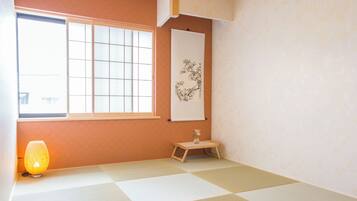 A tatami mat room with a shoji screen, a hanging lantern, and a calligraphy scroll.