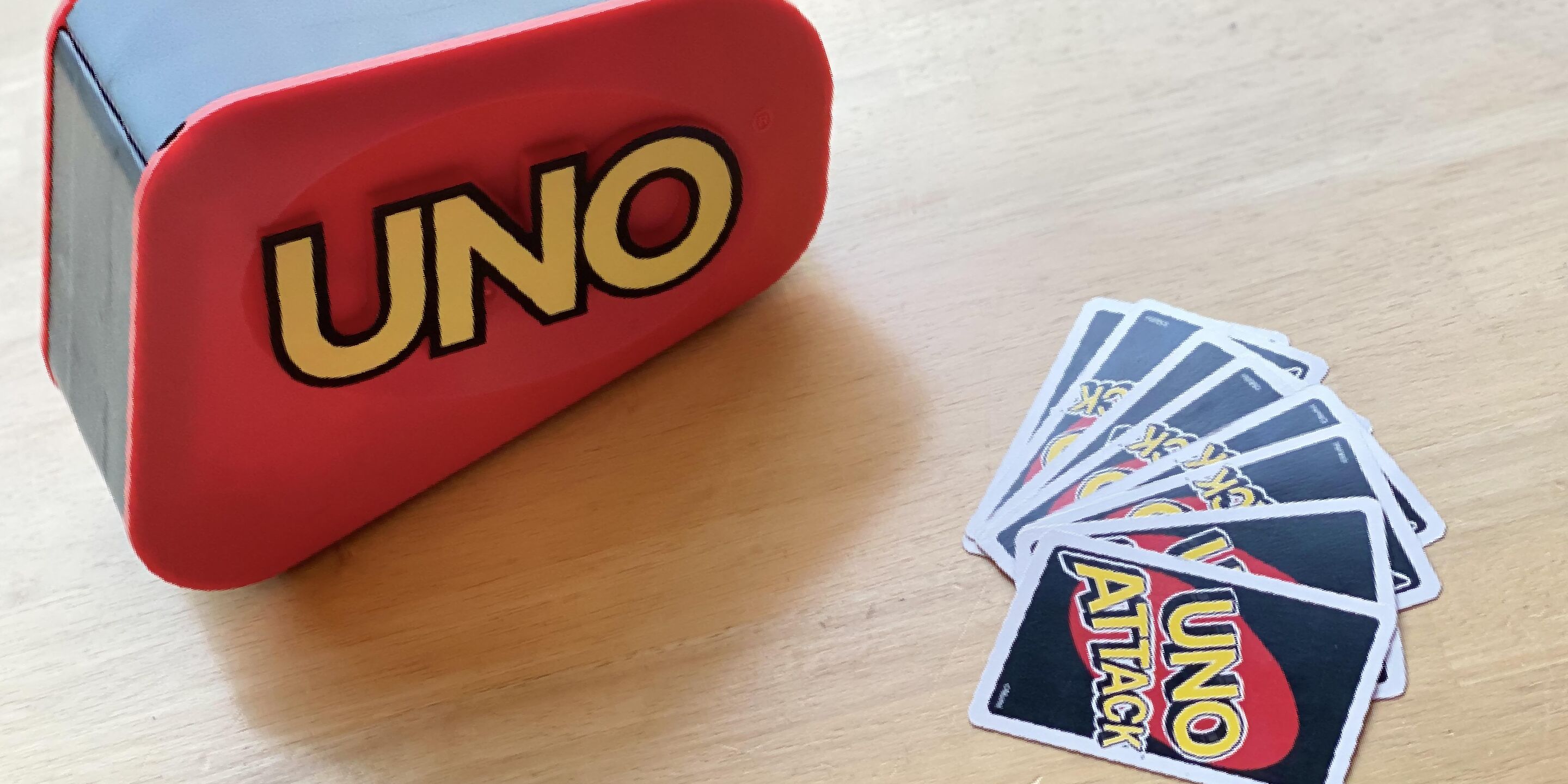 A UNO game box and cards on a wooden surface.