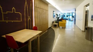 A modern hotel lobby with a reception desk, seating area, and a view of the street through the glass wall. - City Edge Hotel (Kuala Lumpur)