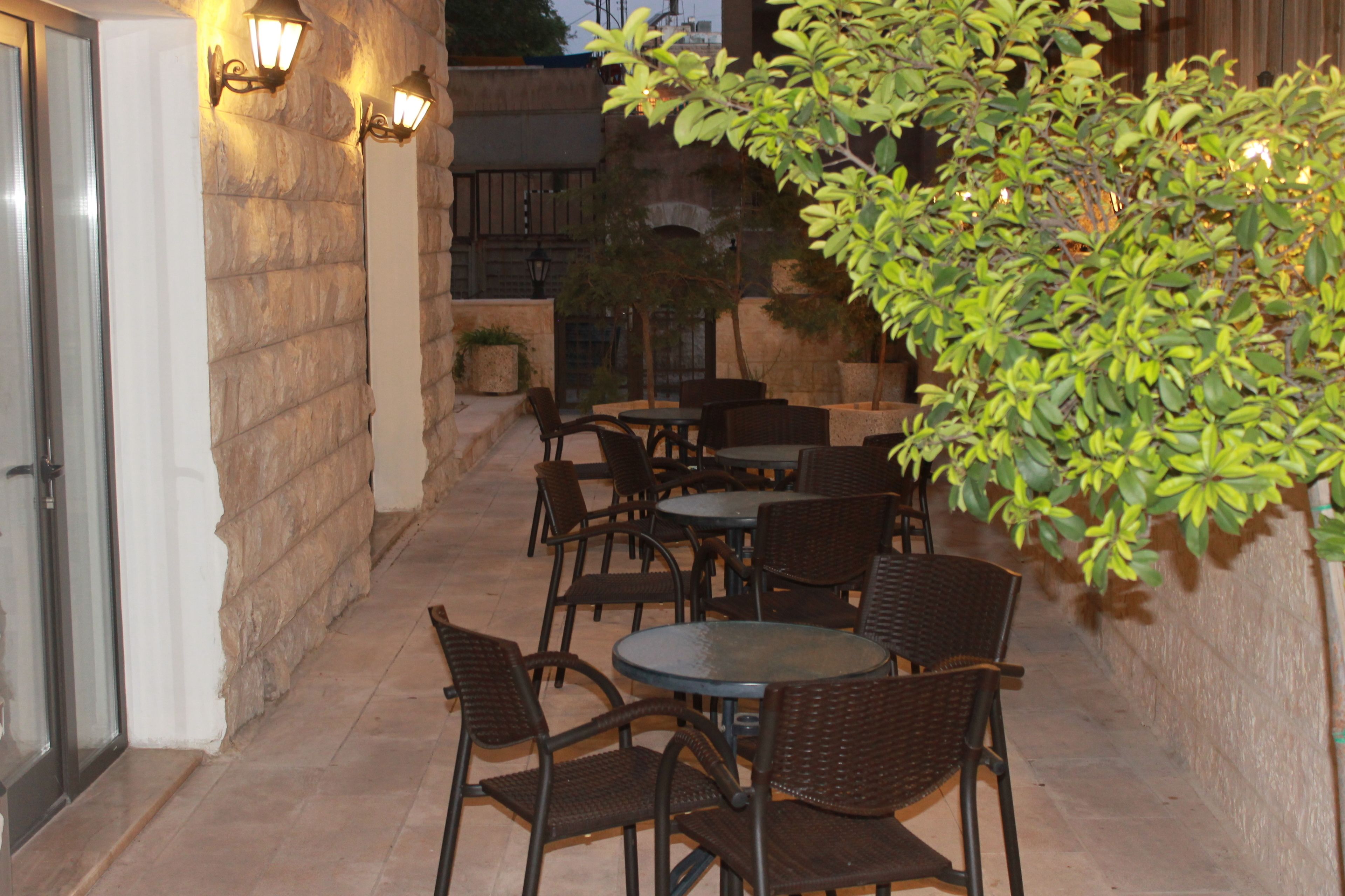 An outdoor patio with stone walls, tables, and chairs.