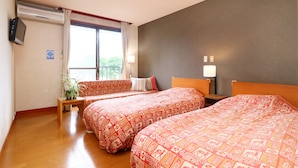 A hotel room with two beds, a small table, a potted plant, and a window with curtains. - Hotel & Restaurant Yesterday (Fujikawaguchiko)