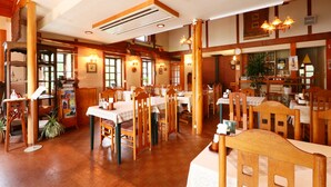 A restaurant with wooden furniture, tables, chairs, and a warm ambiance. - Hotel & Restaurant Yesterday (Fujikawaguchiko)
