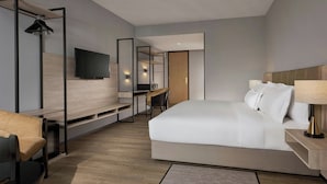 A modern hotel room with a large bed, a desk, a chair, a TV, and a mirror. - AC Hotel by Marriott Puchong (Puchong)