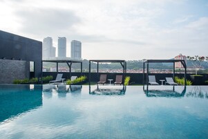 Una piscina al aire libre, tumbonas