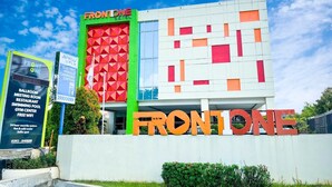 A modern building with the name "FRONTONE HOTEL" prominently displayed. - Front One Hotel Purwodadi (Purwodadi)