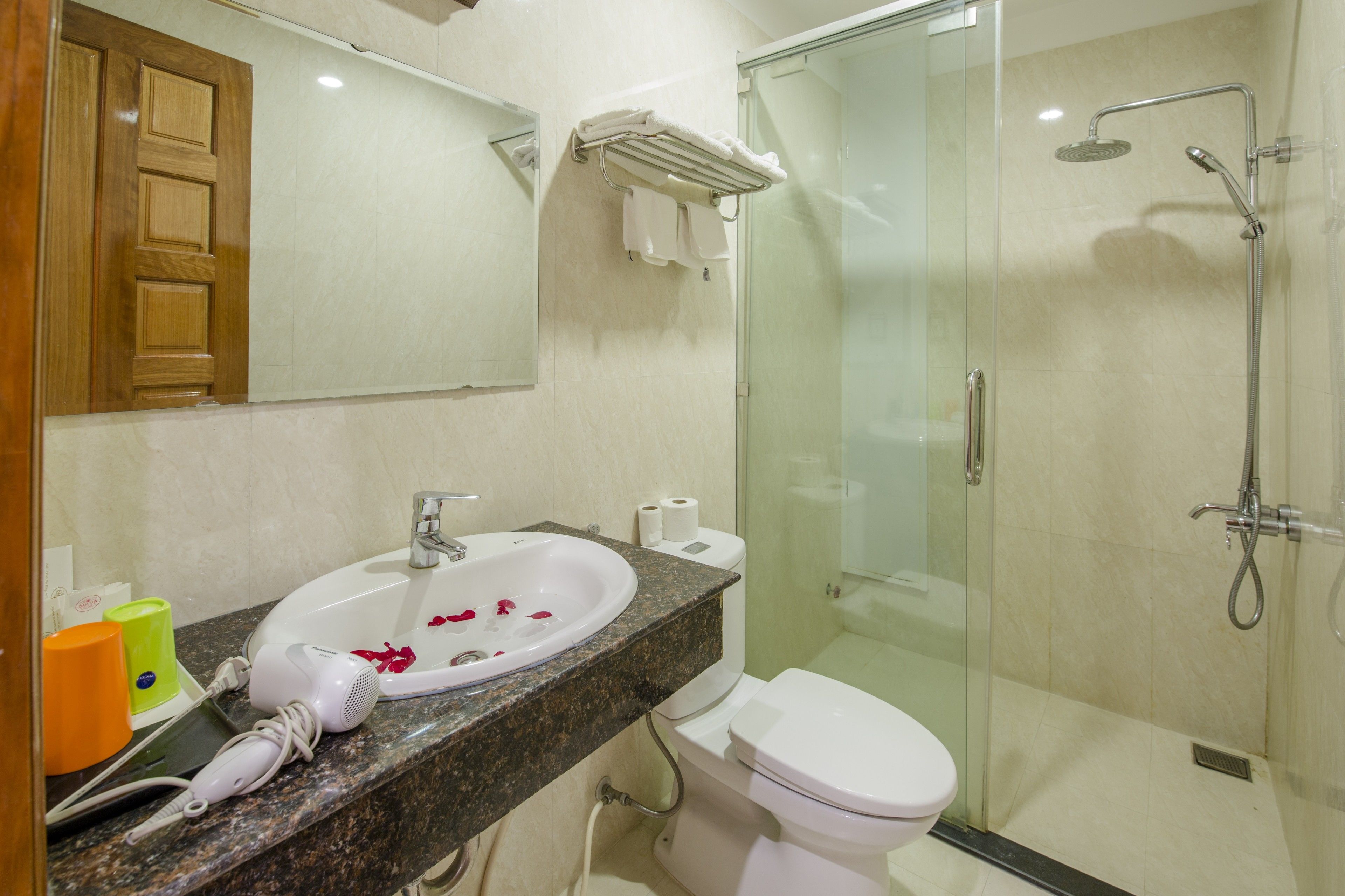 A bathroom with a sink, toilet, and glass shower enclosure.