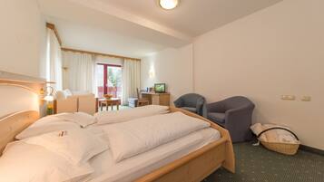 A hotel room with a bed, a desk, a chair, and a television.