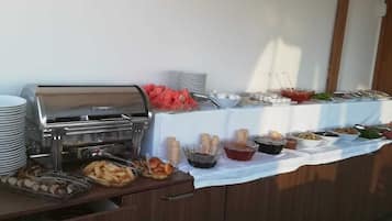 A buffet setup with various food items and a grill station.
