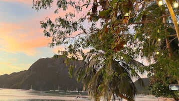 Na praia, areia branca, espreguiçadeiras, toalhas de praia