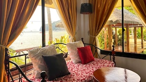 Un lit avec une couvre-lit à motifs rouges et blancs, un oreiller noir et un oreiller rouge.