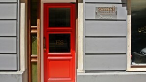 Een rode deur met de letters 'HS' en een bord erboven met de tekst 'semeli semeli Celebrity Club Hotel 16 ELIPASE'.