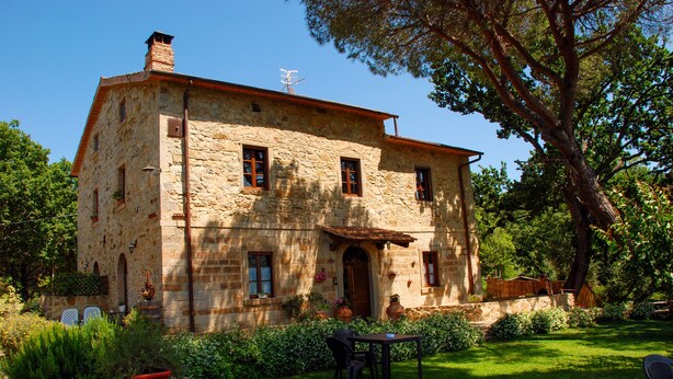 A stone building with a garden and outdoor seating. - La Mulattiera (Scarlino)