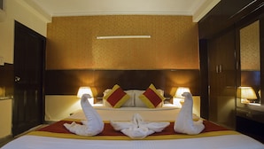 Une chambre d’hôtel avec un lit, deux lampes et une décoration en forme de cygne réalisée avec des serviettes.