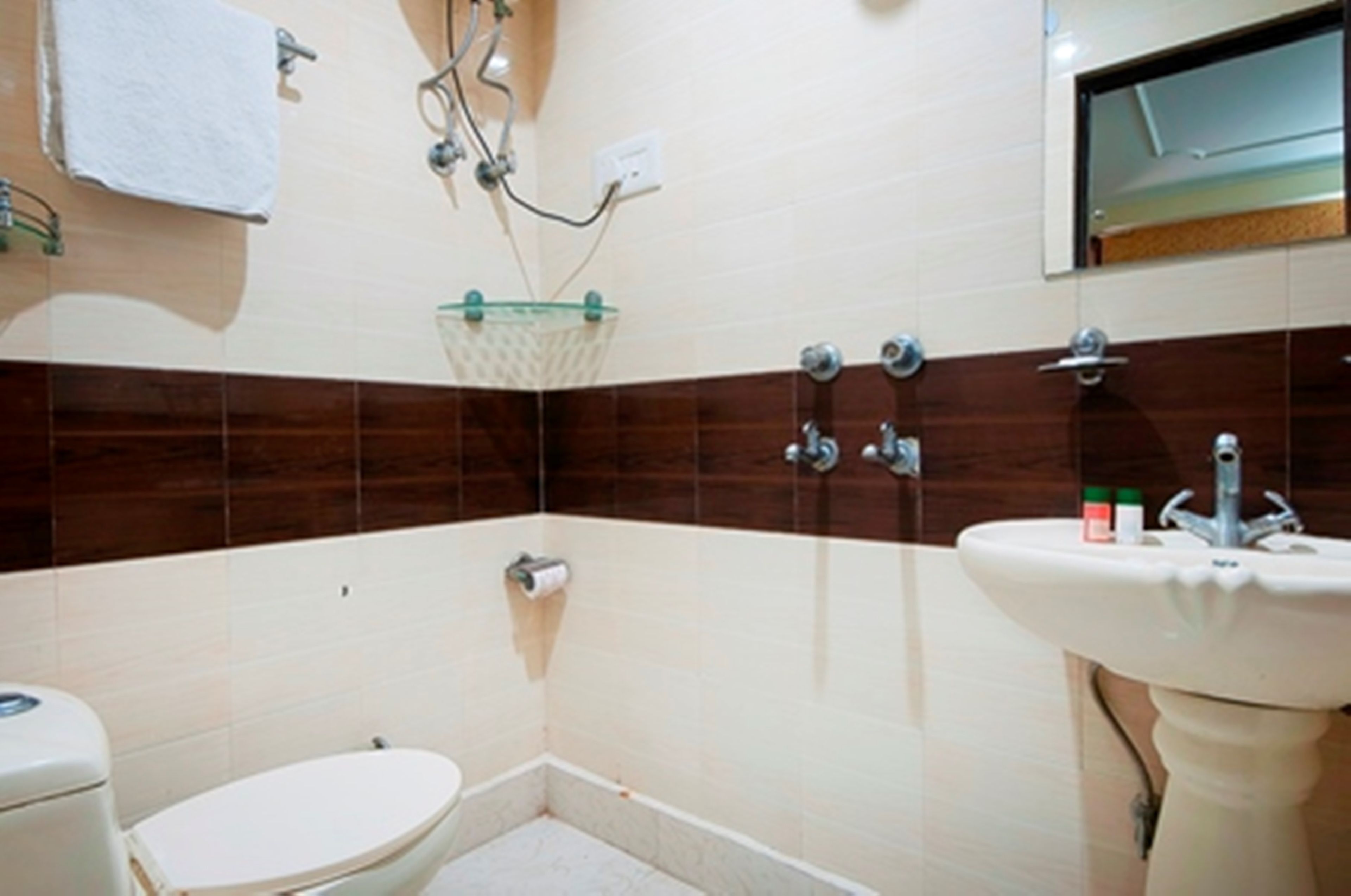 Un baño pequeño con inodoro, lavabo y ducha.