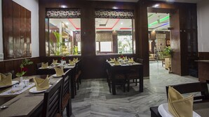 Un restaurant doté de nombreuses tables, chacune étant dressée avec des assiettes, des couverts et des serviettes.