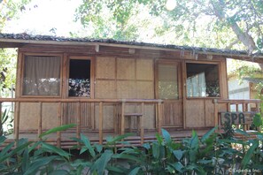 A wooden building with a bamboo exterior, a sign indicating a spa, and a covered porch area.