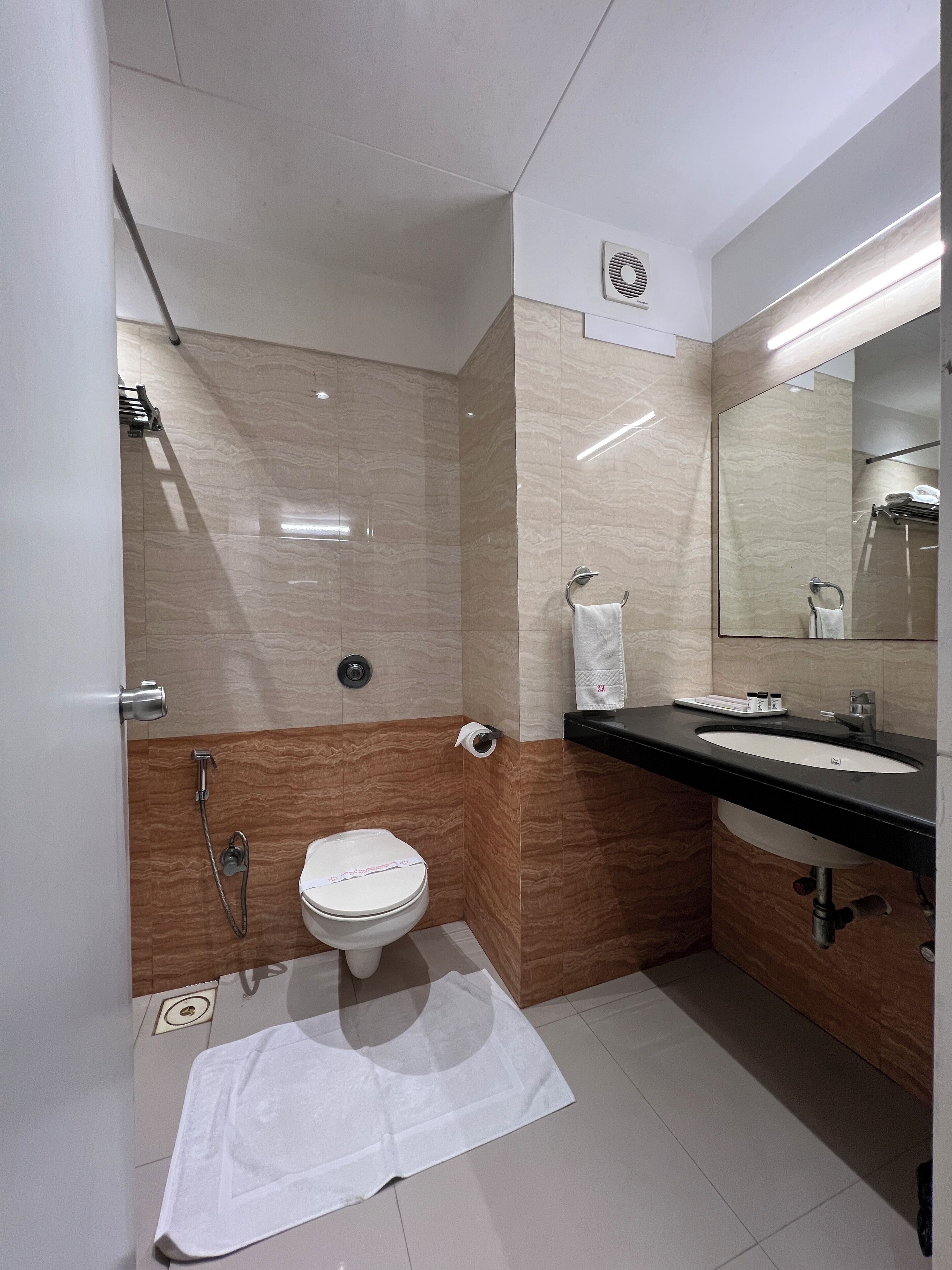 Un bagno moderno con WC, lavandino e doccia.