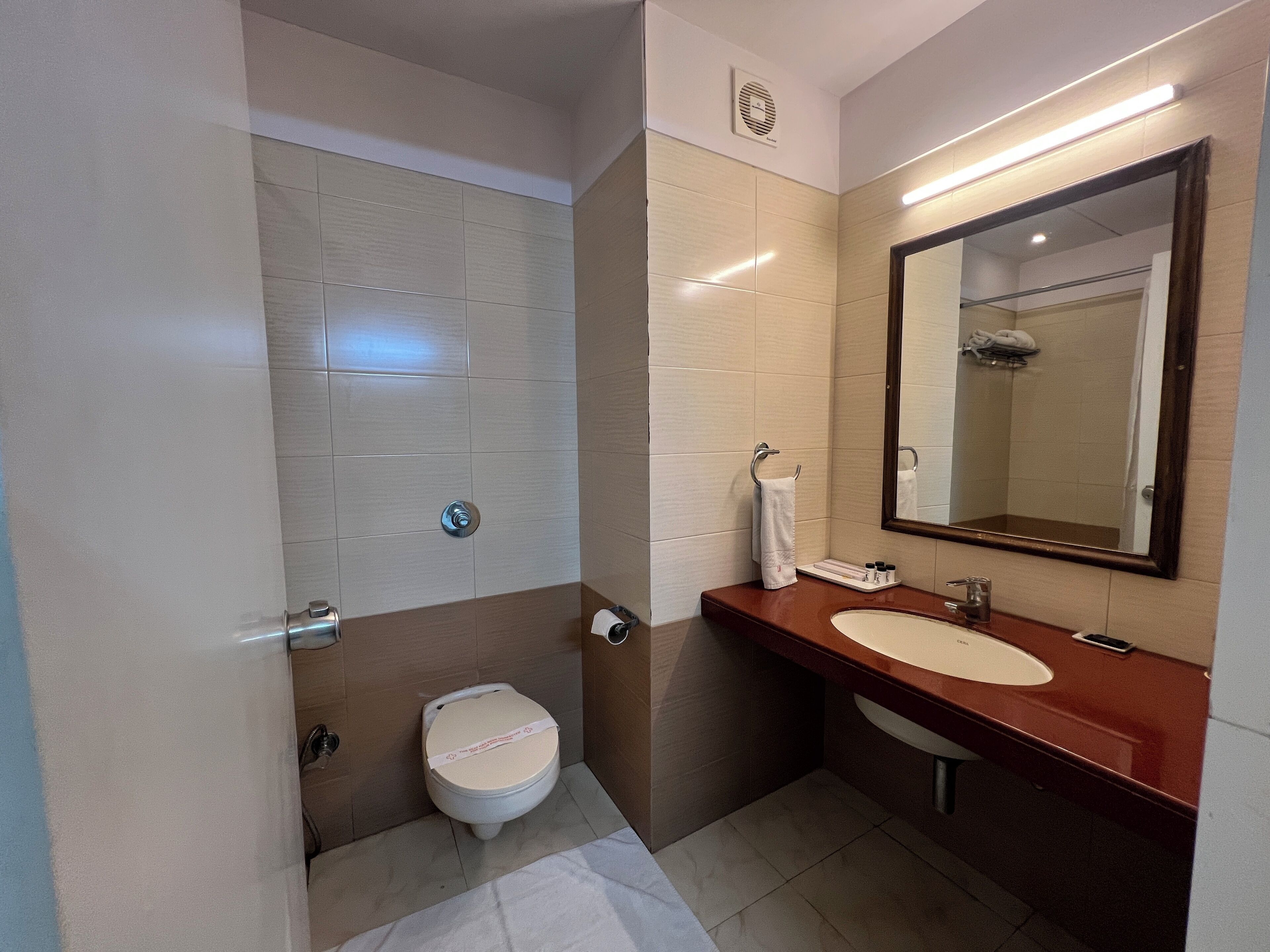 Et moderne badeværelse med toilet, vask og spejl.