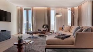 A modern living room with a sofa, armchair, coffee table, and a TV.