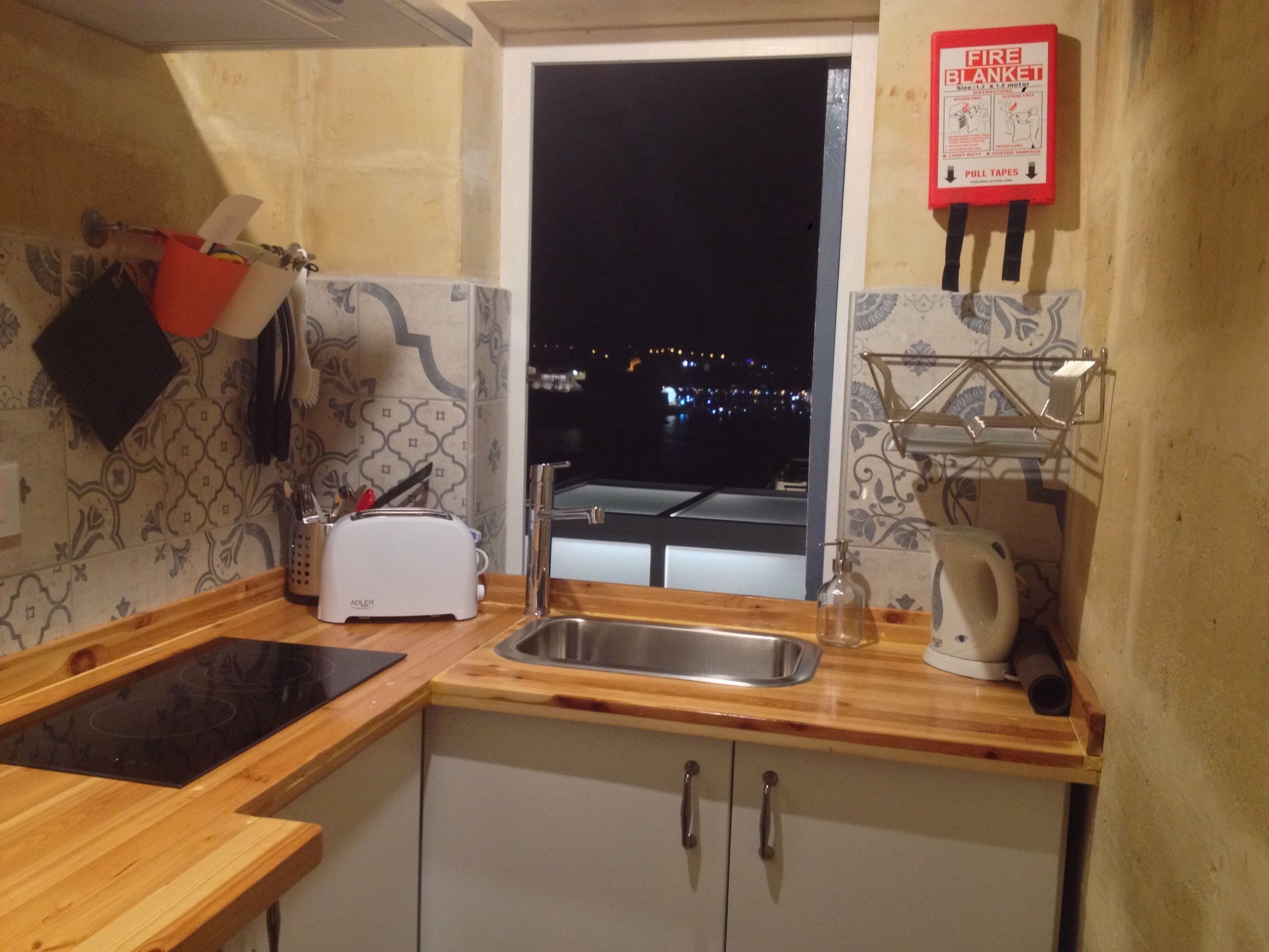 Cucina con lavello, tostapane e finestra che si affaccia su un panorama notturno.
