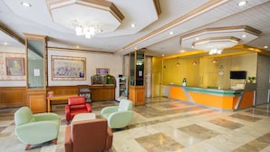 A lobby with a reception desk, seating area, and artwork on the walls. - Lake Inn Hotel (Songkhla)