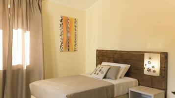 A neatly arranged bedroom with a bed, a bedside table, and a wall-mounted light fixture.