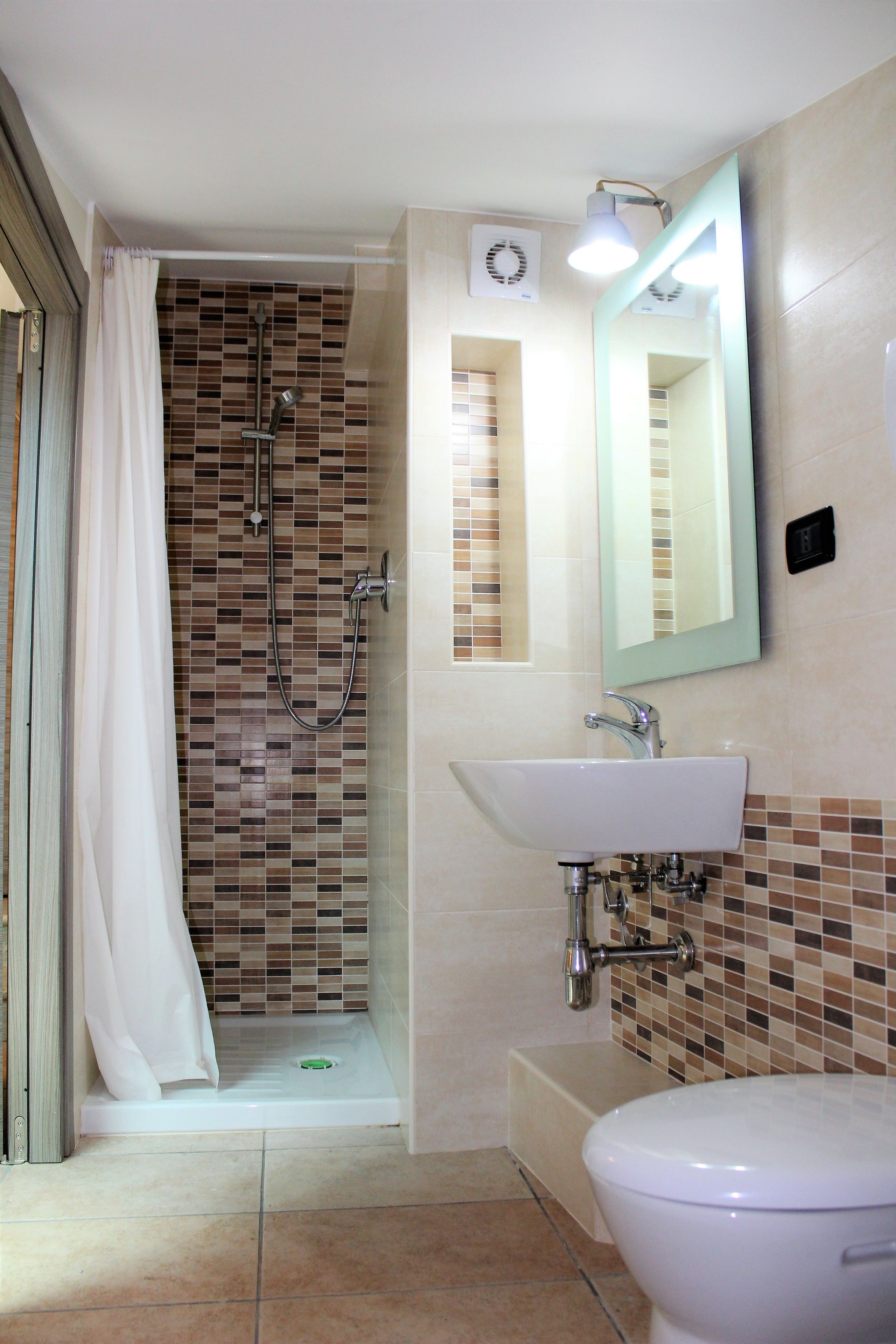 A bathroom with a shower, sink, and toilet.