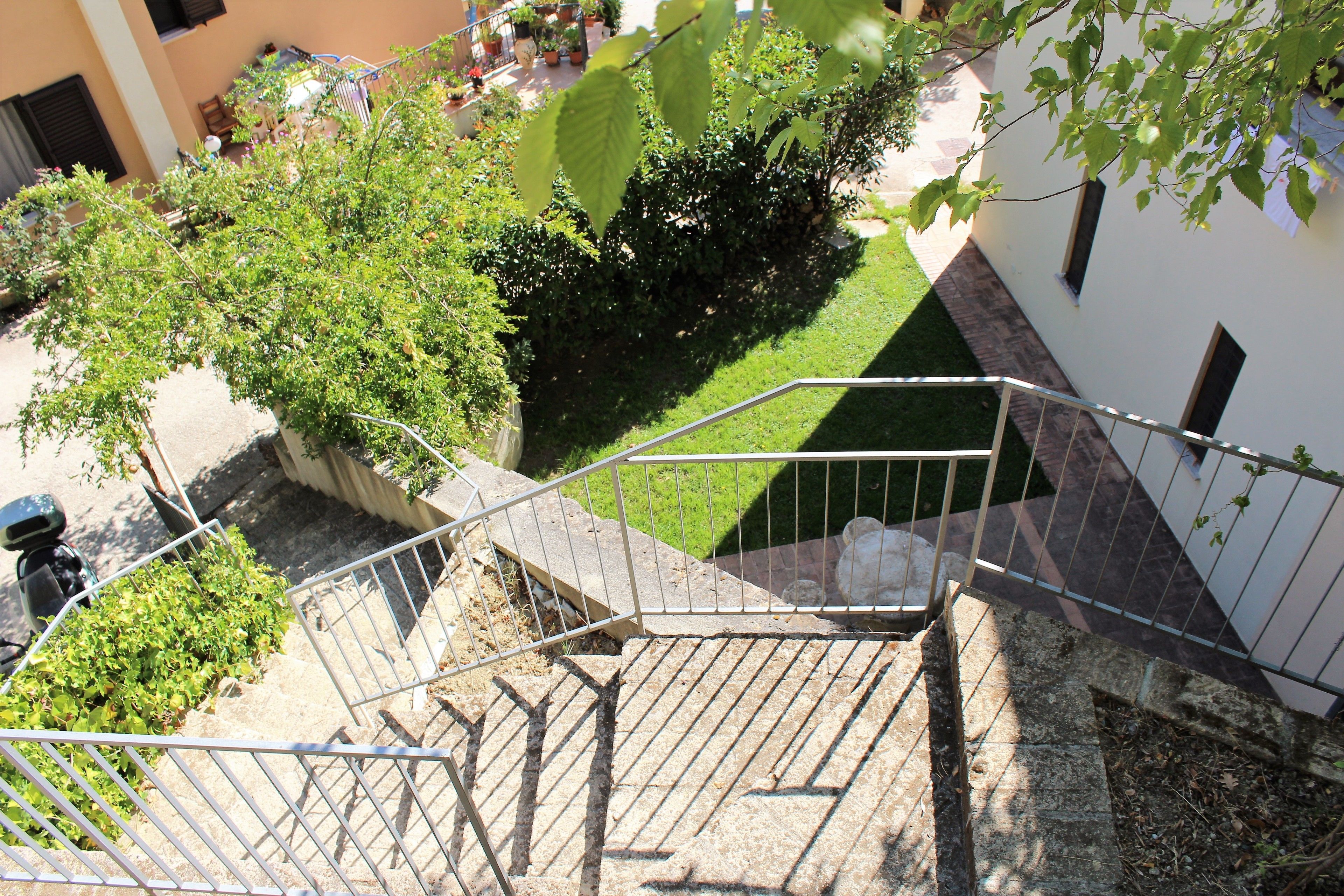 A staircase leading to a building with a small garden area and a parked scooter. - BBuSS Country Club (Catanzaro)