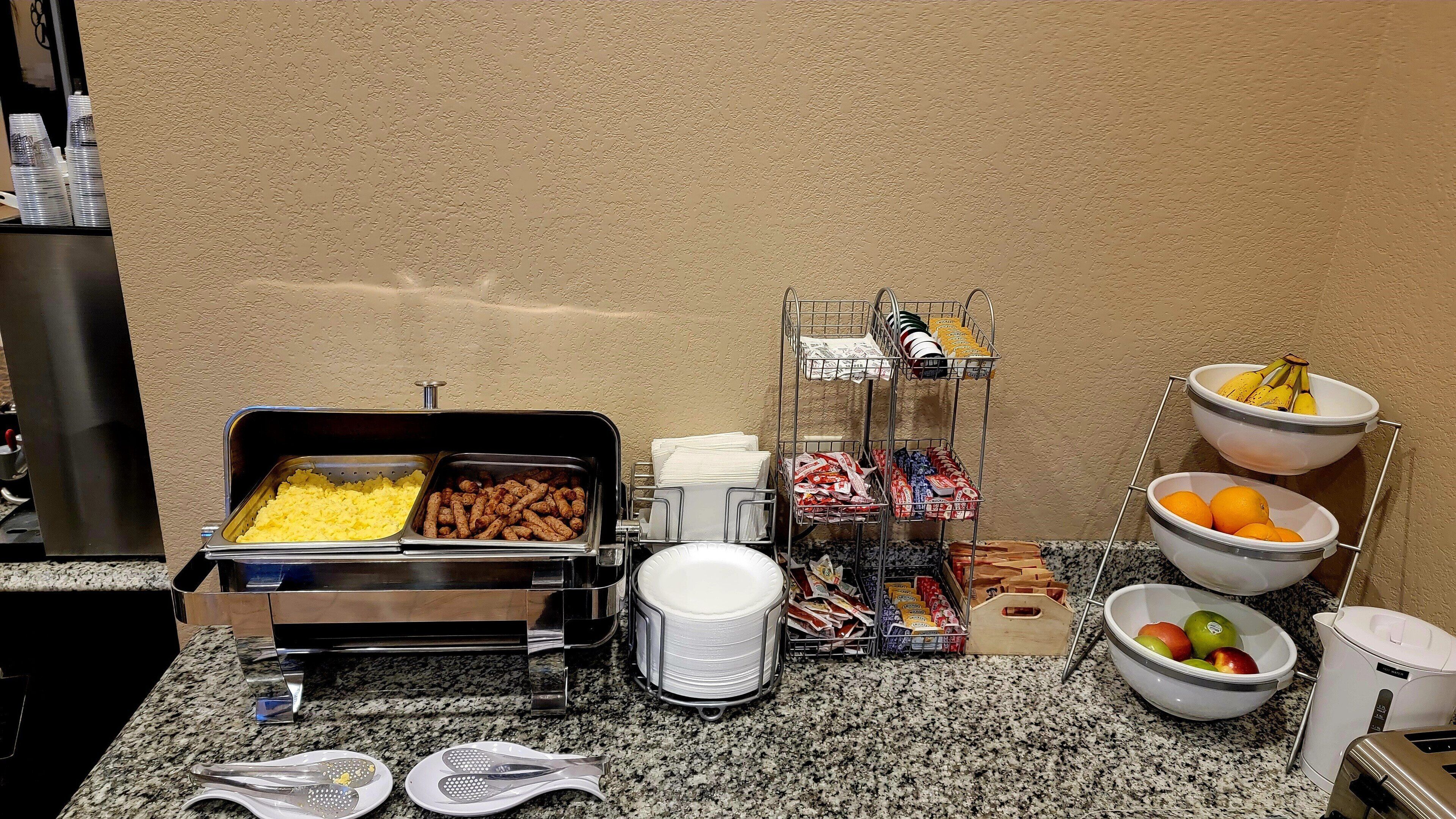 A buffet setup with various food items and condiments.