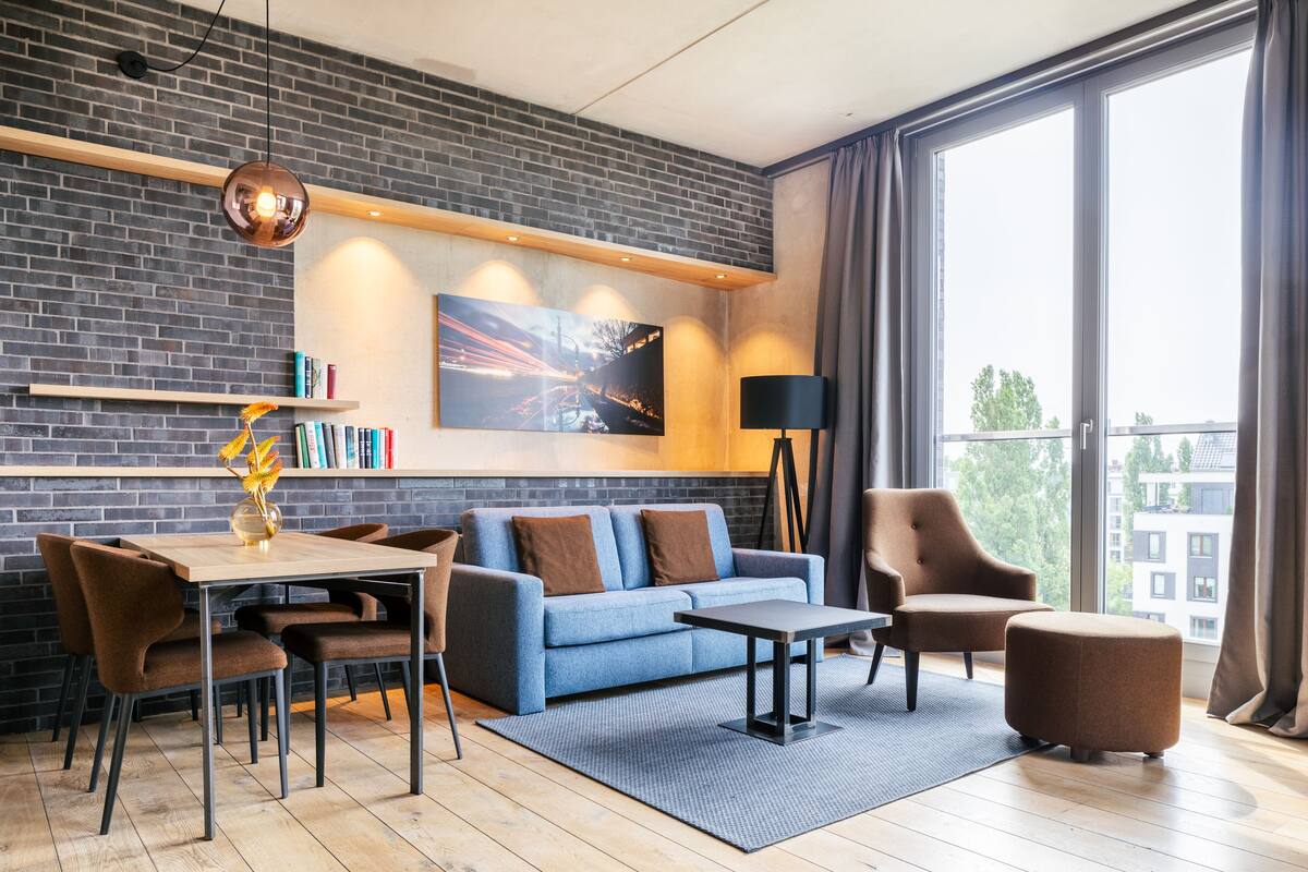 A modern living room with a sofa, chairs, a coffee table, and a bookshelf.