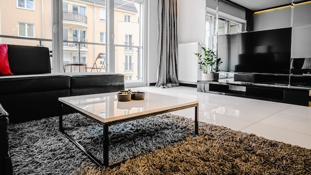 A modern living room with a sofa, a coffee table, and a TV. - Apartamenty Homely Place City (Poznan)