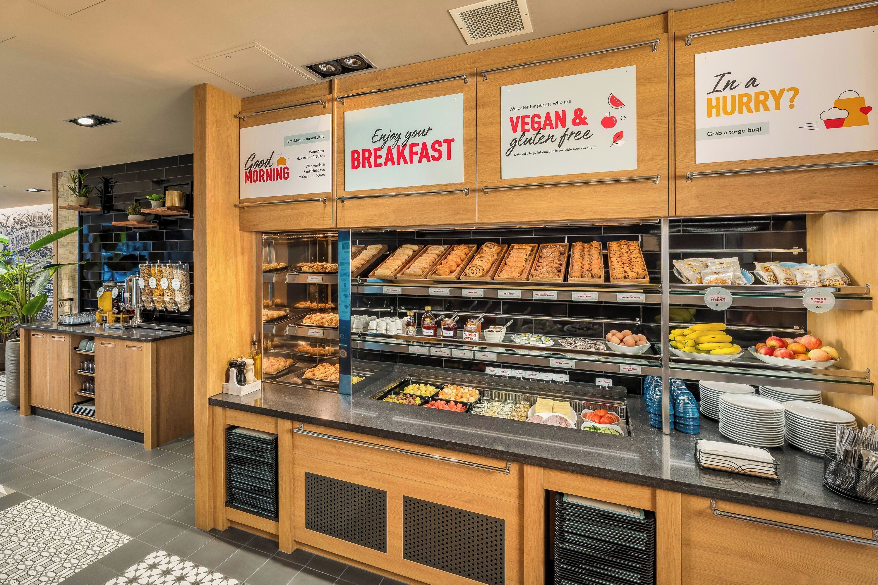 En morgenmadsbuffet med et bredt udvalg af mad, herunder frugt, bagværk og drikkevarer.