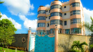 A multi-story hotel with a distinctive curved facade, large windows, and a gated entrance. - Stardom Hotel (Nairobi)