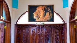 A grand wooden door with intricate carvings and a lion painting above it, labeled "VIP Lounge." - Stardom Hotel (Nairobi)
