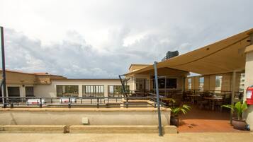 A building with outdoor seating, a covered area, and a fire extinguisher.