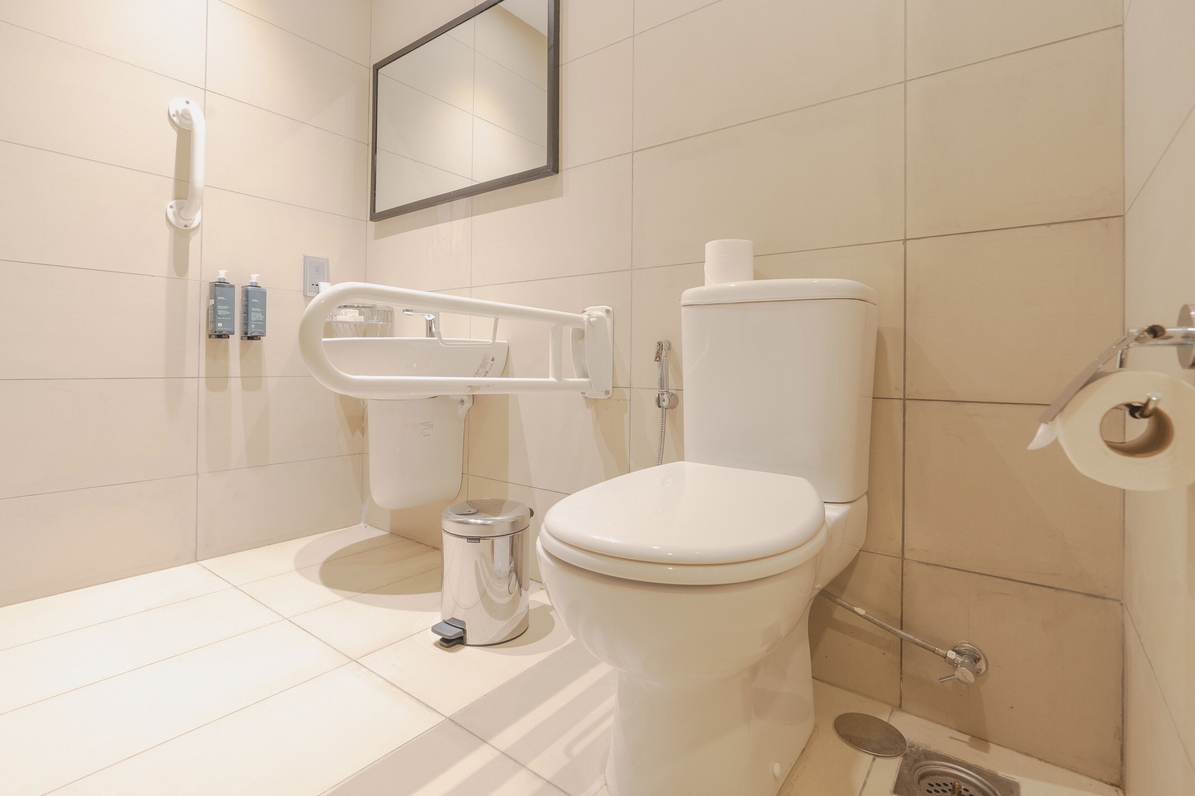 A modern bathroom with a toilet, bidet, and hand dryer.
