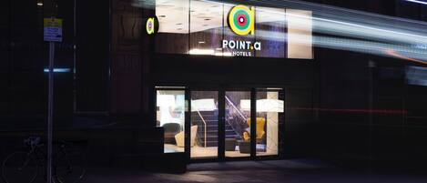 Entrada de un hotel con un cartel que dice 'POINT.C HOTELS'.
