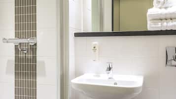 A bathroom with a shower, sink, and toilet.